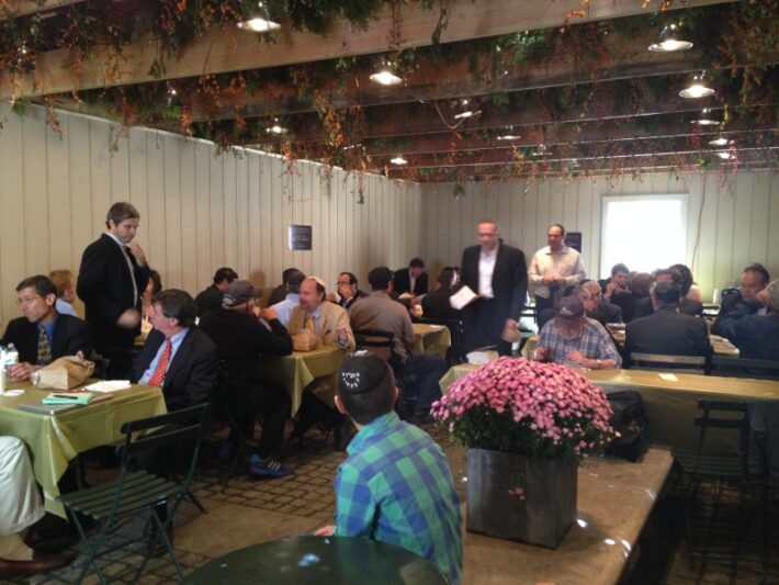 Munching on their lunch, more than eighty people pack into the sukka on a bustling Monday afternoon in Manhattan. Photo: Rachel Delia Benaim