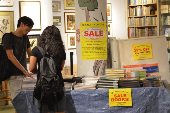 Evan Wung, far left, and Ezen Wang browse through Books of Wonder's store-wide book sale, hosted during the week of Labor Day for its 35th anniversary.