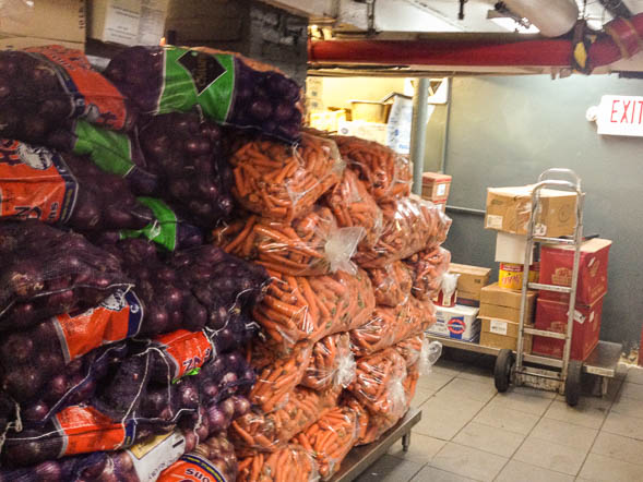 Stacks of carrots and onions in the storage room beneath Holy Apostles Soup Kitchen.  Photo: James K. Williamson. 