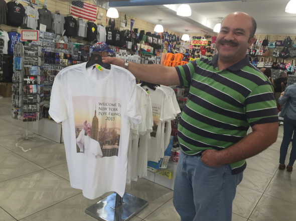 Ahmed Abouelela, shop assistant at Grand Slam New York shows off the shop’s pope merchandise.