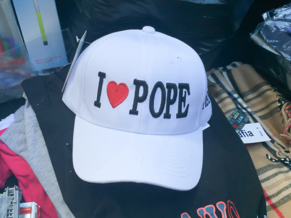 Vendors selling clothing have added pope-inspired attire to their garment list. A cap costs $8.
