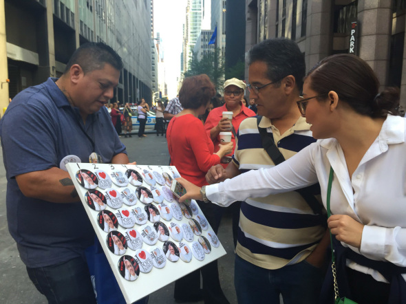 Juan Vazquez (right) walked up and down a winding line selling buttons with the image of the pope to people in front of St Patrick’s Cathedral. 