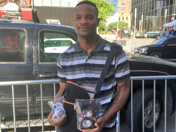Lafayette Worthy from Queens is perched in front of Madison Square Garden selling his souvenir buttons. “Today has been slow but I know it will pick up later in the day.”