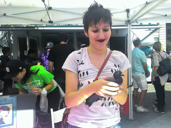 Julia Kite, a volunteer at the Wild Bird Fund, shows passersby a pigeon blinded in one eye.