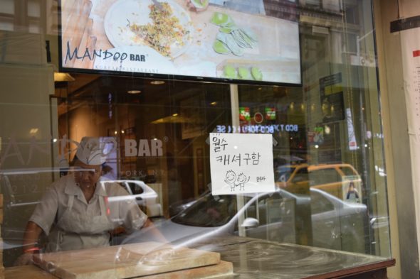 A cook for Mandoo Bar prepares Korean dumplings in a window that looks out onto 32nd Street.