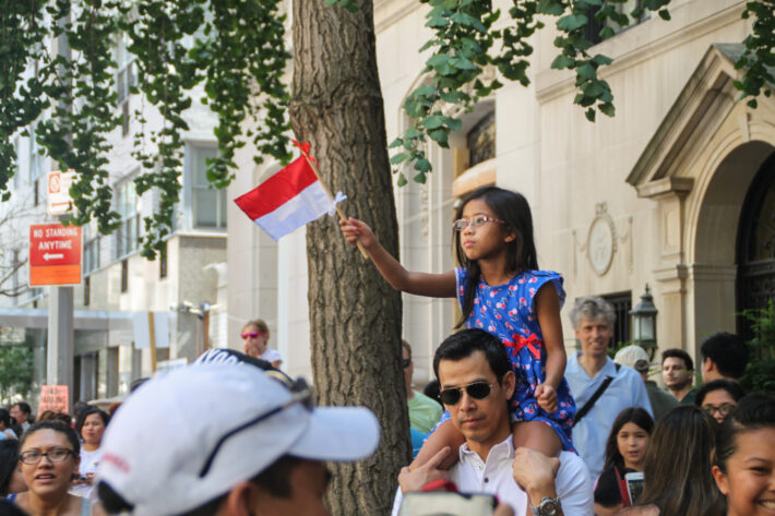 A young girl on her father's shoulders gets the best seat in the house. 